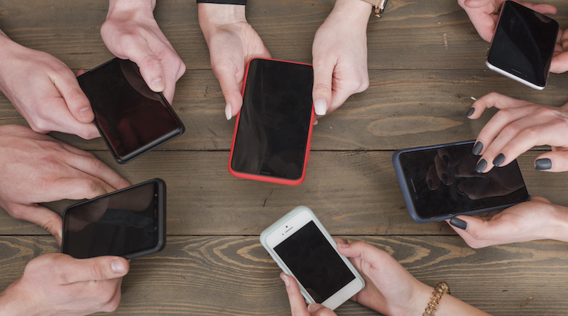 Varias personas comparando móviles sobre una mesa